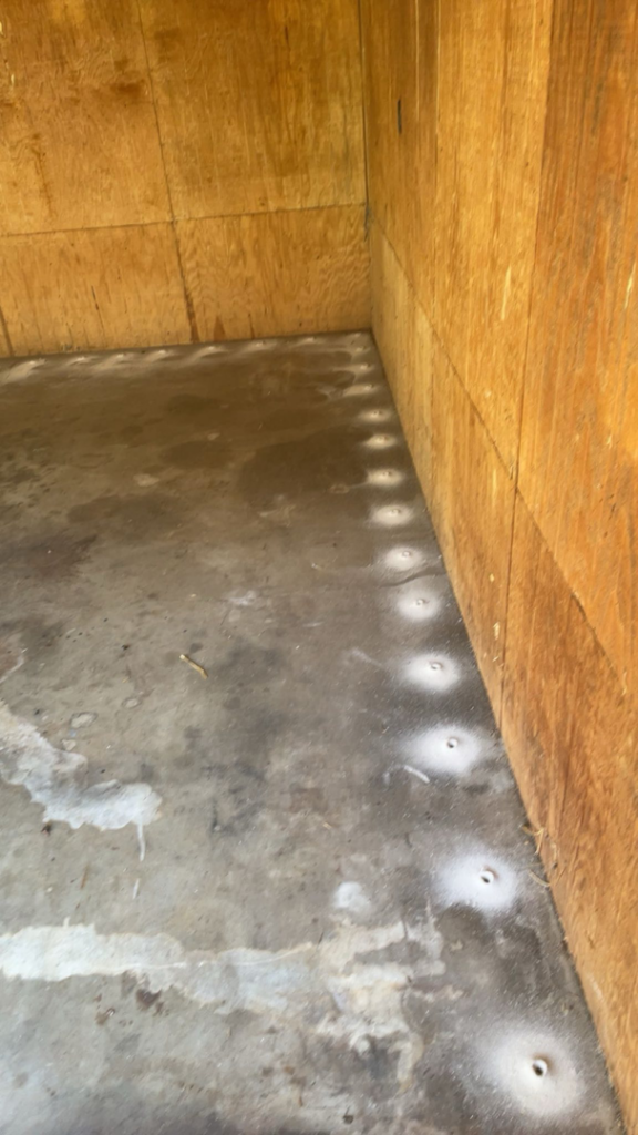 Drilled holes in a concrete floor for termite treatment by Best Termite & Pest Control, Inc. in Manchester, KY.