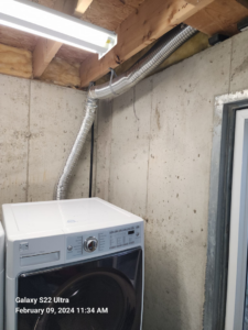 A flexible dryer vent duct connected to a laundry unit, showing dryer vent cleaning work by Pro Power Air Duct & Dryer Vent Cleaning in Kenosha, WI.