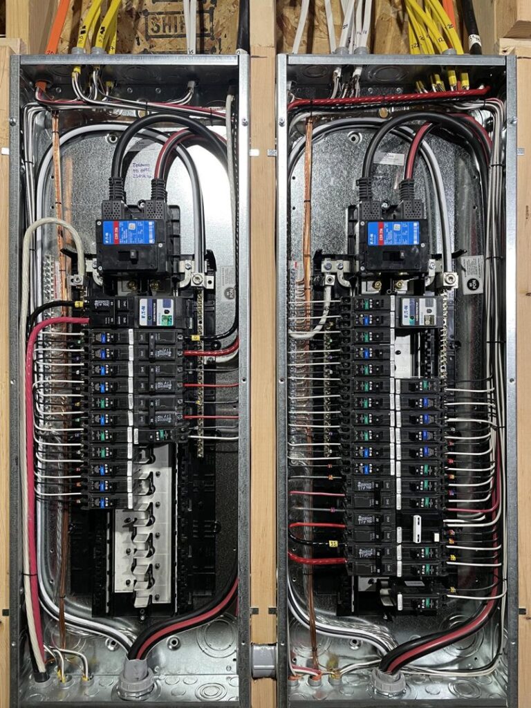 Two newly installed electrical breaker panels with organized wiring by Kot Electric LLC in Kent, WA.