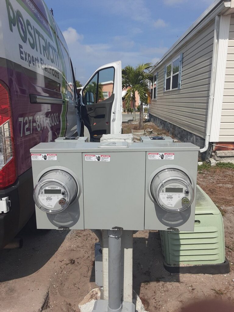 Two outdoor electricity meters installed on a pole with a Positricity service van in the background in Clearwater, FL.