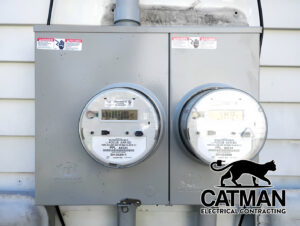 Two modern exterior electrical meters installed on a white siding wall, showcasing work by Catman Electrical Contracting in Dallas, PA.
