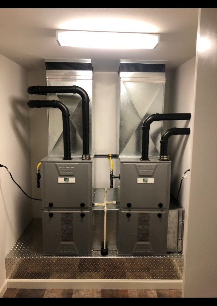 Two modern furnaces with ductwork and piping installed by Custom Mechanical Systems INC., an HVAC contractor in Wasilla, AK