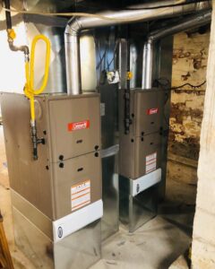 Two indoor furnace or air handler units with connected ductwork and gas lines installed by Deboque Duct Design Corp. in Staten Island, NY