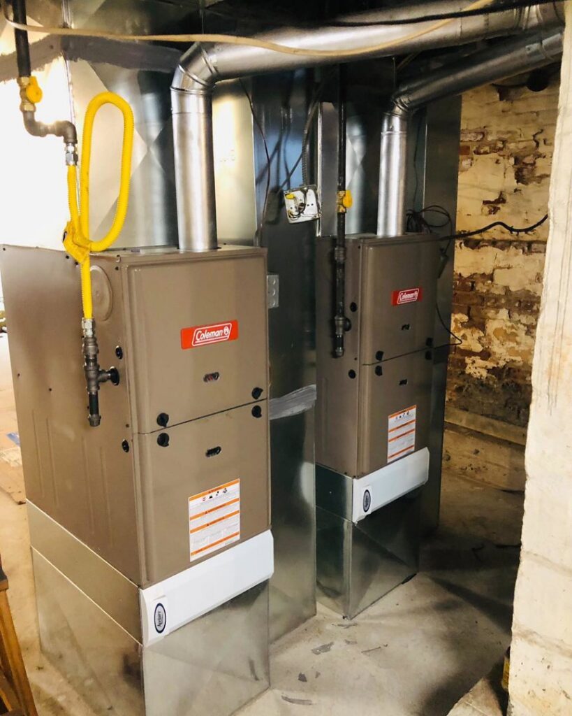 Two indoor furnace or air handler units with connected ductwork and gas lines installed by Deboque Duct Design Corp. in Staten Island, NY