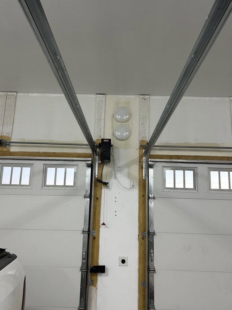 An interior view of a dual garage door system undergoing inspection or service by SS Garage Door Repair in Denver, CO.