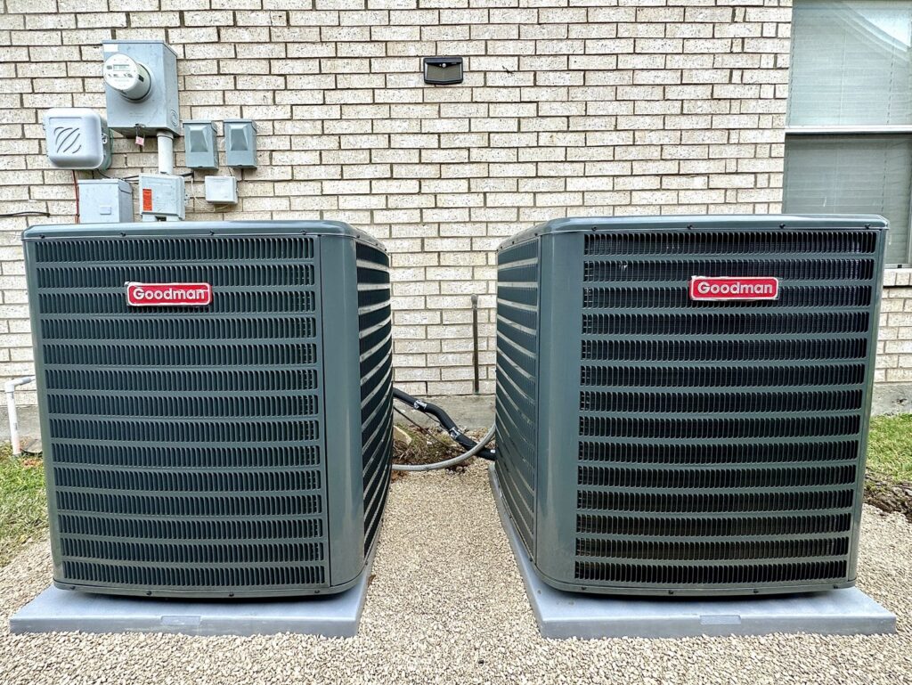 Two outdoor Goodman AC units installed side-by-side by Texas Air & Heat in Arlington, TX.