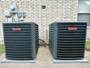 Two outdoor Goodman AC units installed side-by-side by Texas Air & Heat in Arlington, TX.