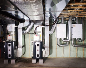 Two indoor HVAC units with extensive ductwork and piping installed in a basement by Allied Heating and Air Conditioning in Port Richey, FL.