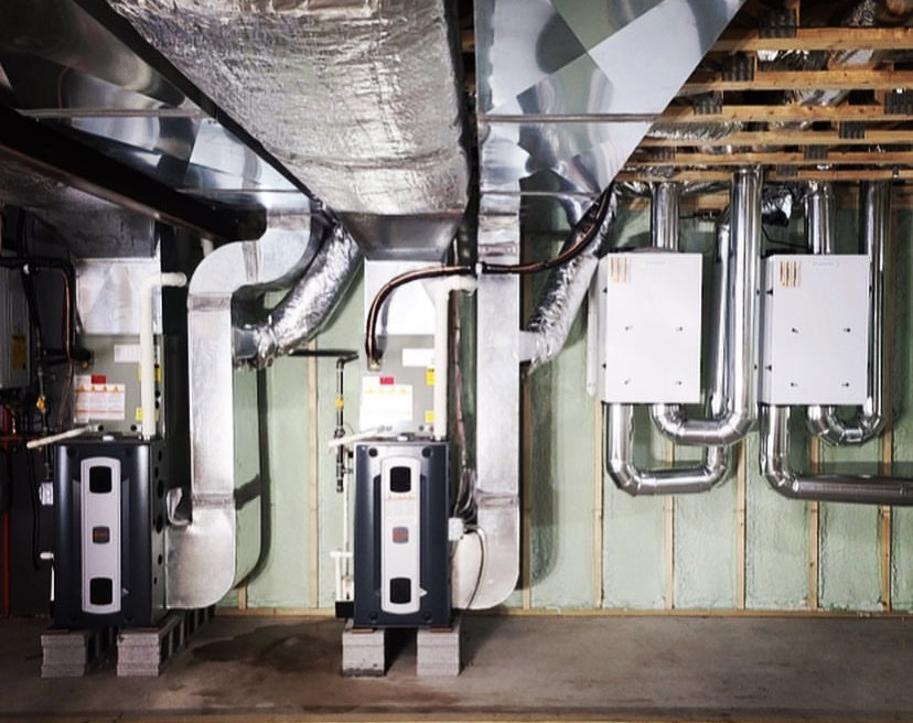 Two indoor HVAC units with extensive ductwork and piping installed in a basement by Allied Heating and Air Conditioning in Port Richey, FL.