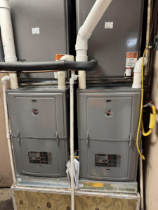 Two indoor HVAC furnace units with associated ductwork and piping, installed by Indoor Weather Solutions LLC in Broken Arrow, OK.