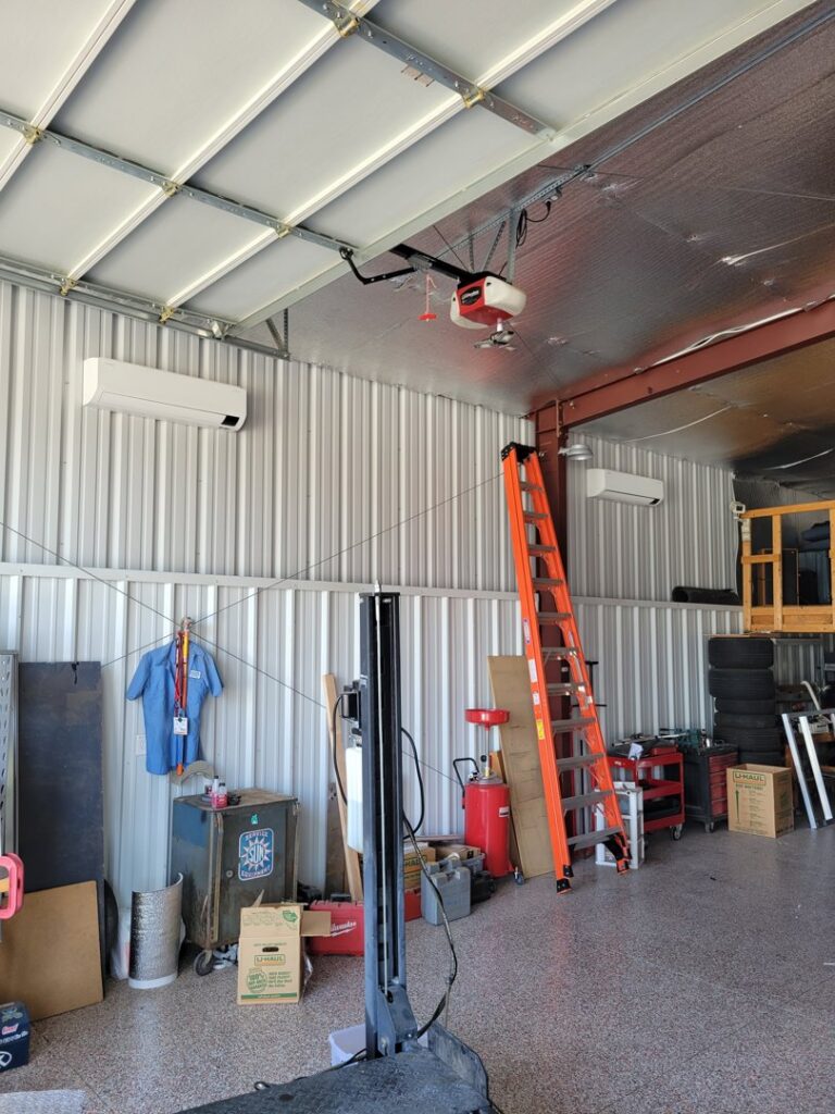 Two indoor mini-split head units installed in a garage or workshop by J & M Cooling & Heating LLC in Peoria, AZ.
