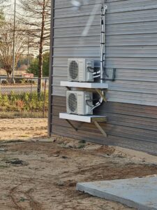 Two outdoor mini-split condenser units professionally installed on a building wall by Advance Heating & Air, Inc. in Sumter, SC.