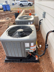 Two outdoor air conditioning condenser units installed next to a residential property by Fast Air in Zebulon, NC.
