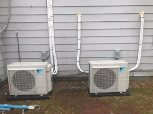Two outdoor HVAC condenser units professionally installed next to a residential building by Comfort Coach in Glade Hill, VA