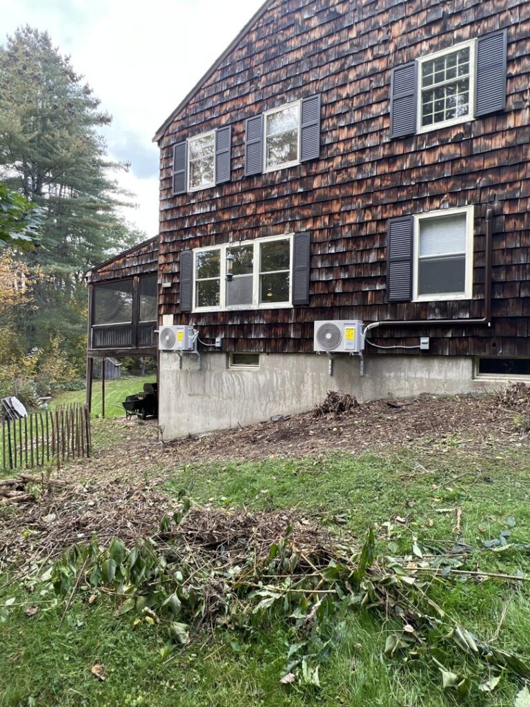 Two outdoor HVAC units professionally installed on the side of a residential building by Laird's HVAC in Auburn, ME.