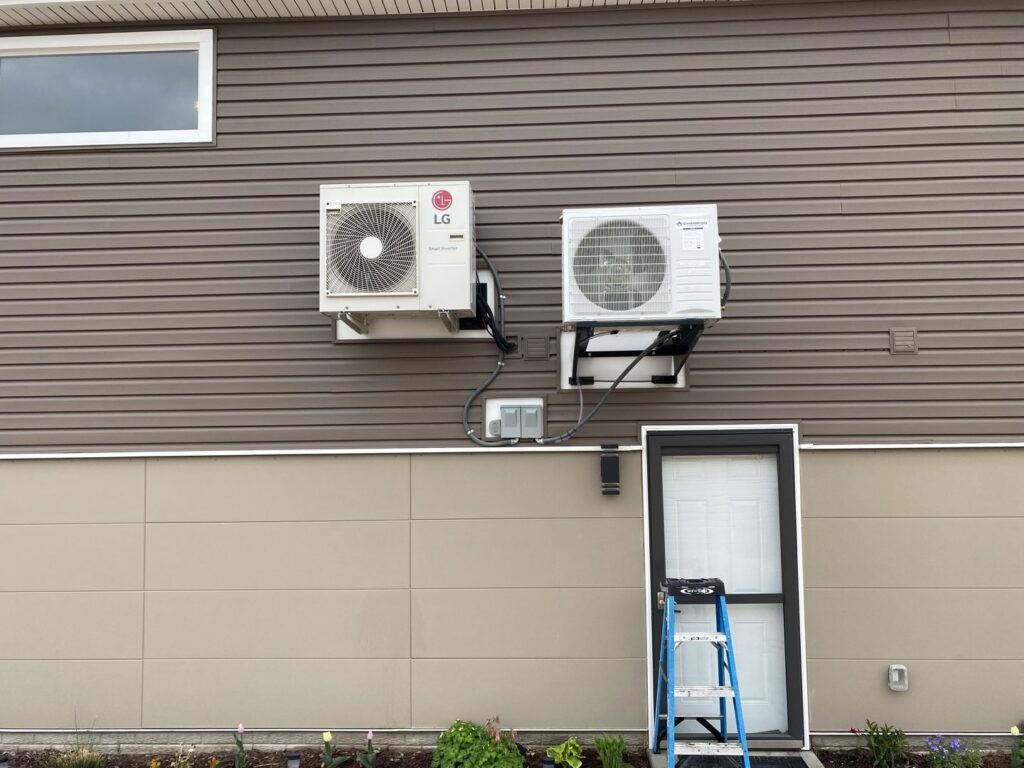 Two outdoor mini-split condenser units professionally installed on the side of a house by Millard Heating & Cooling in Elkhorn, NE.