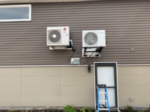 Two outdoor mini-split condenser units professionally installed on the side of a house by Millard Heating & Cooling in Elkhorn, NE.