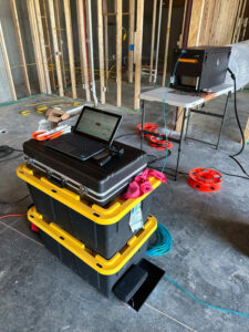 Duct sealing equipment and a laptop set up on site in a framed room by Green Seal Energy in Overland Park, KS.