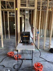 Duct sealing equipment set up in a new construction home with exposed framing by Green Seal Energy in Overland Park, KS.