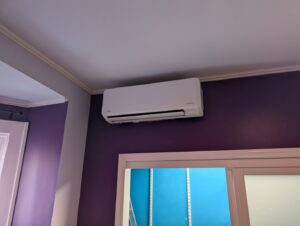 A ductless mini-split indoor unit installed on a purple wall by Strine's Heating & A/C in York, PA.