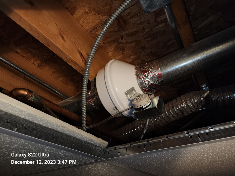 A booster fan installed within ductwork in a ceiling, indicating HVAC ventilation services by Pro Power Air Duct & Dryer Vent Cleaning in Kenosha, WI.