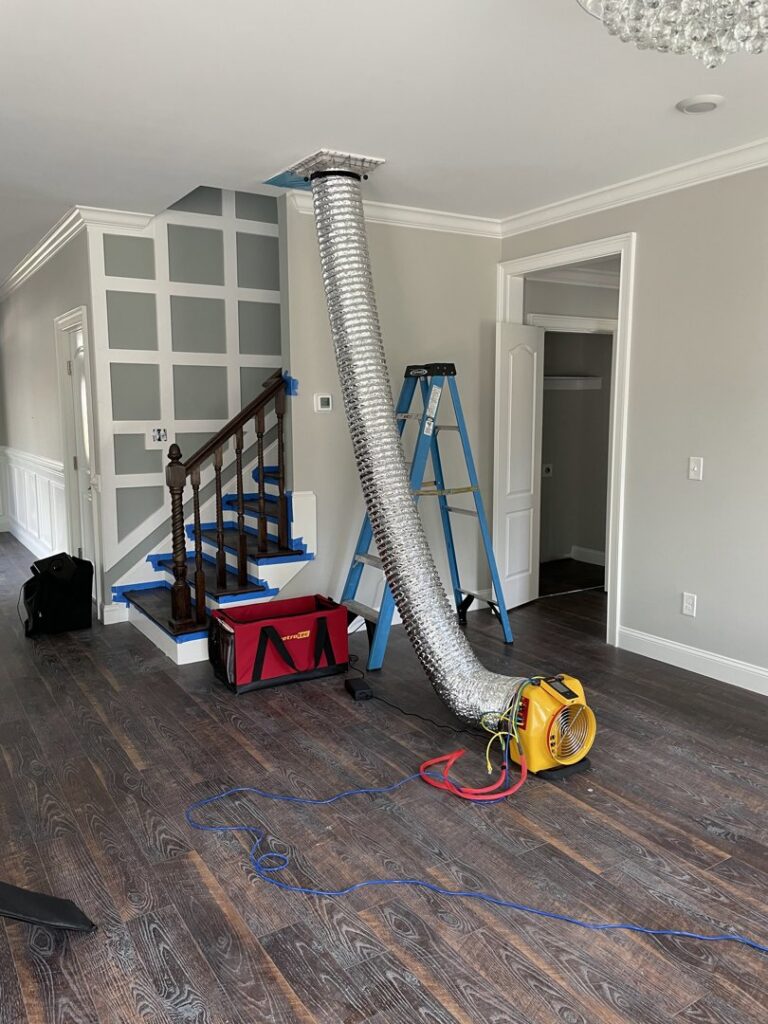 A blower fan and flexible ductwork connected to a ceiling vent for HVAC system testing by Reliable Heating and Air LLC in Summerville, SC.