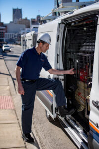 A DUCTZ of Siouxland technician in a hard hat entering a service van, prepared for an HVAC job in Vermillion, SD.