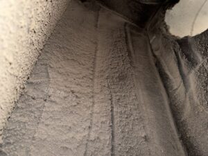 Extremely dusty HVAC ductwork interior before cleaning, highlighting the need for services from AirHero.Pro in Lafayette, LA.