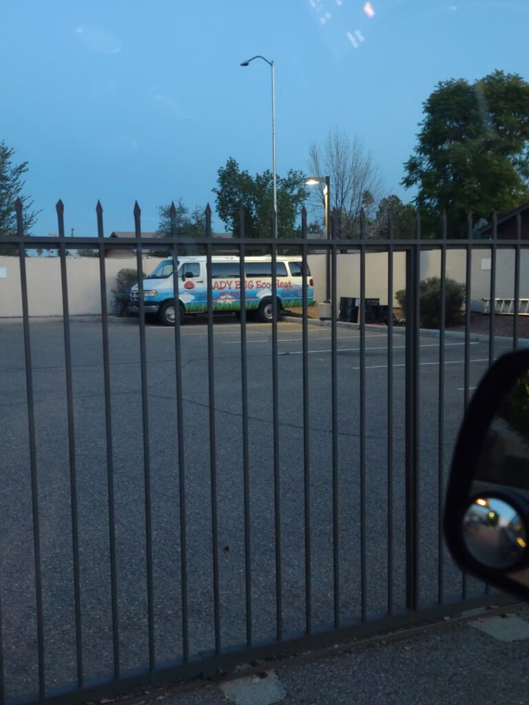 A Lady Bug ECO FRIENDLY Pest Control Eco-Heat van parked behind a fence, indicating bed bug services in Mesa, AZ.