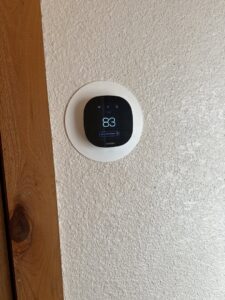 An Ecobee smart thermostat installed on a textured wall by Aircon Heating and Cooling Inc in Las Cruces, NM
