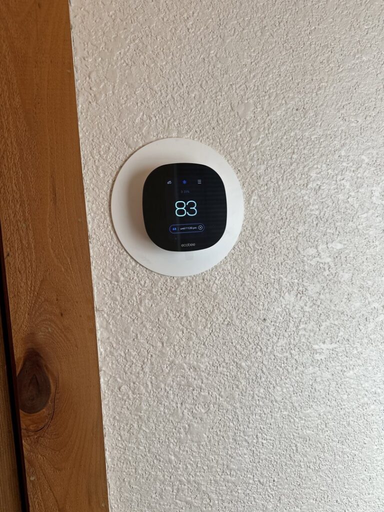 An Ecobee smart thermostat installed on a textured wall by Aircon Heating and Cooling Inc in Las Cruces, NM