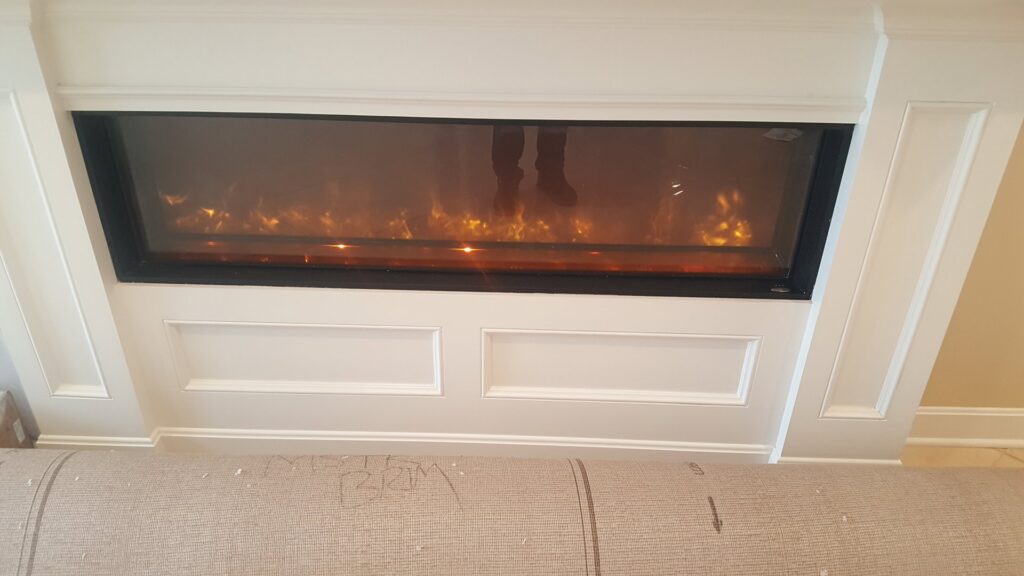 A modern electric fireplace installed in a living room wall by Fiedler Electric in Higginsville, MO.