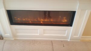 A modern electric fireplace installed in a living room wall by Fiedler Electric in Higginsville, MO.
