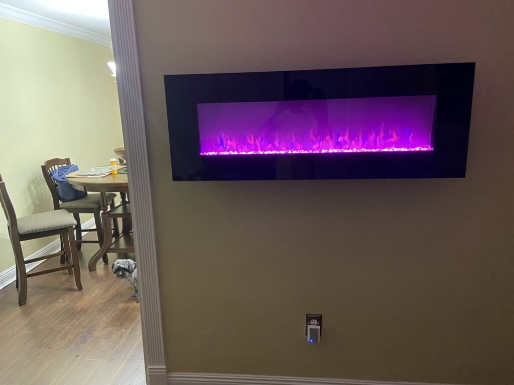 A wall-mounted electric fireplace with purple flames installed by Joule Electrical A/C & Heating Services in New Orleans, LA.