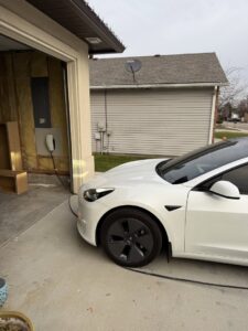 An electric vehicle charger installed in a garage, ready for use, by All 4 You Electrical in Boise, ID.