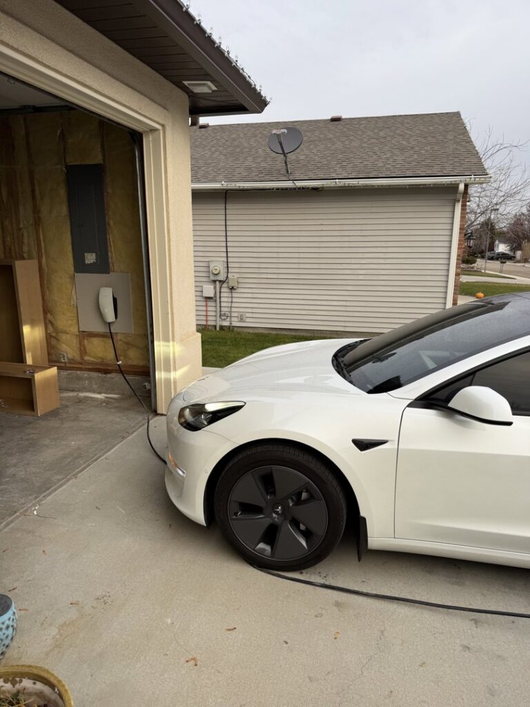 An electric vehicle charger installed in a garage, ready for use, by All 4 You Electrical in Boise, ID.