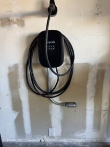 An Emporia electric vehicle charger installed on a garage wall by Eco Electric in Las Vegas, NV.