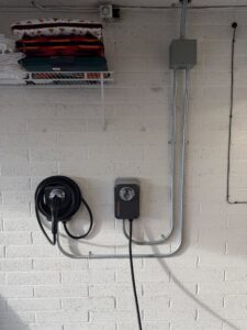 Electric vehicle (EV) charger installed on a brick wall with conduit by Silo Electric in Gilbert, AZ