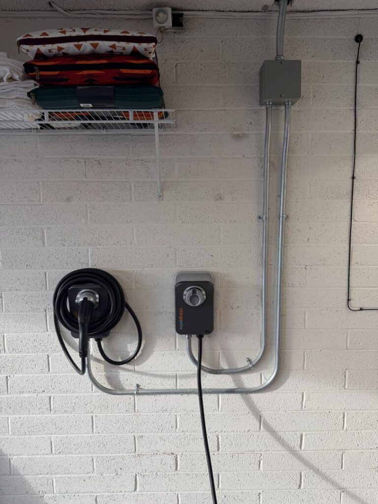 Electric vehicle (EV) charger installed on a brick wall with conduit by Silo Electric in Gilbert, AZ