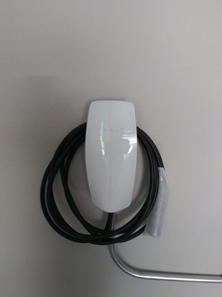 An electric vehicle charger installed on a wall, a service provided by Tesla Alarm and Electrical in Plano, TX