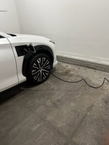An electric vehicle charging in a garage, showcasing EV charging solutions by Black Power Redevelopers in Papillion, NE.