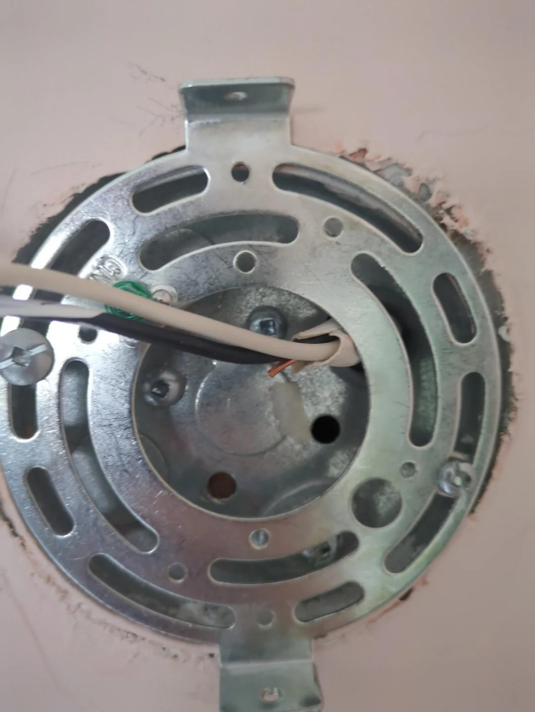 An electrical box mounting bracket with wiring being installed by Ask Electricians in Los Angeles, CA.