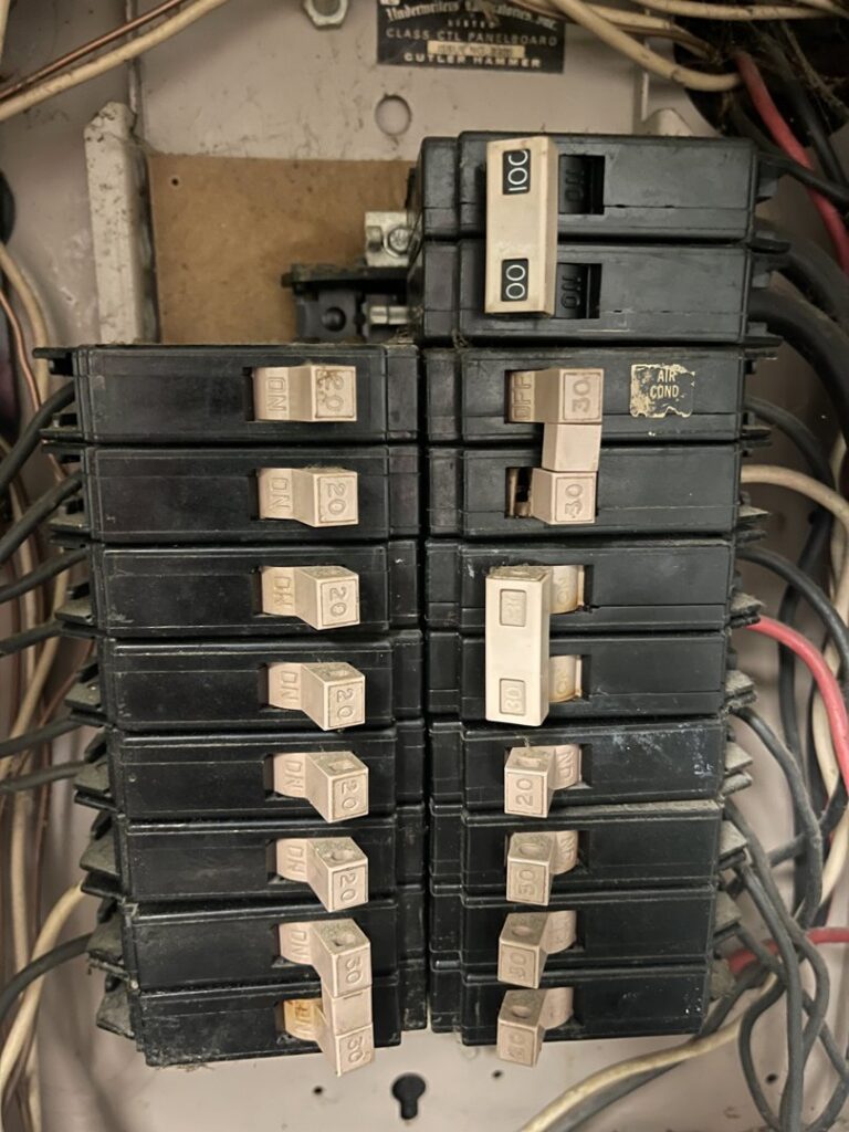 An electrical breaker panel showing the "AIR COND" breaker, indicating electrical service related to HVAC systems by DeltaCool in Jonesboro, AR.