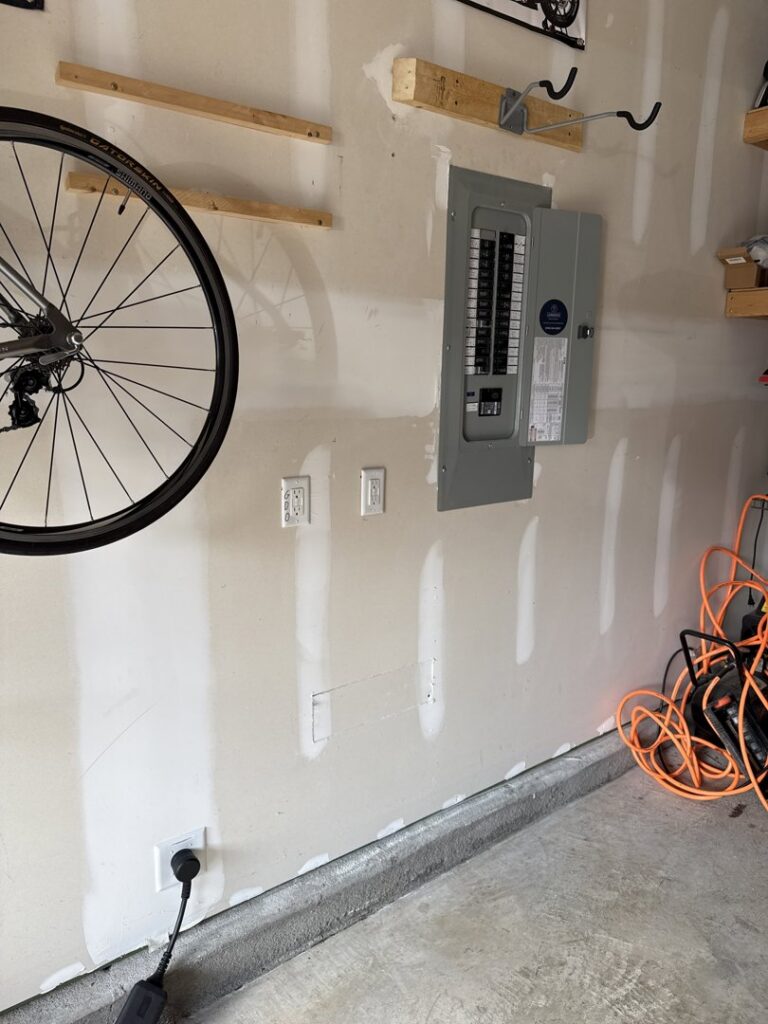 An electrical breaker panel and new outlets installed in a garage by LivElectric in Garner, NC.