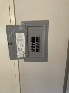 An open electrical breaker panel showing circuit breakers, serviced by Outlaw Home Services, LLC in San Antonio, Tx.