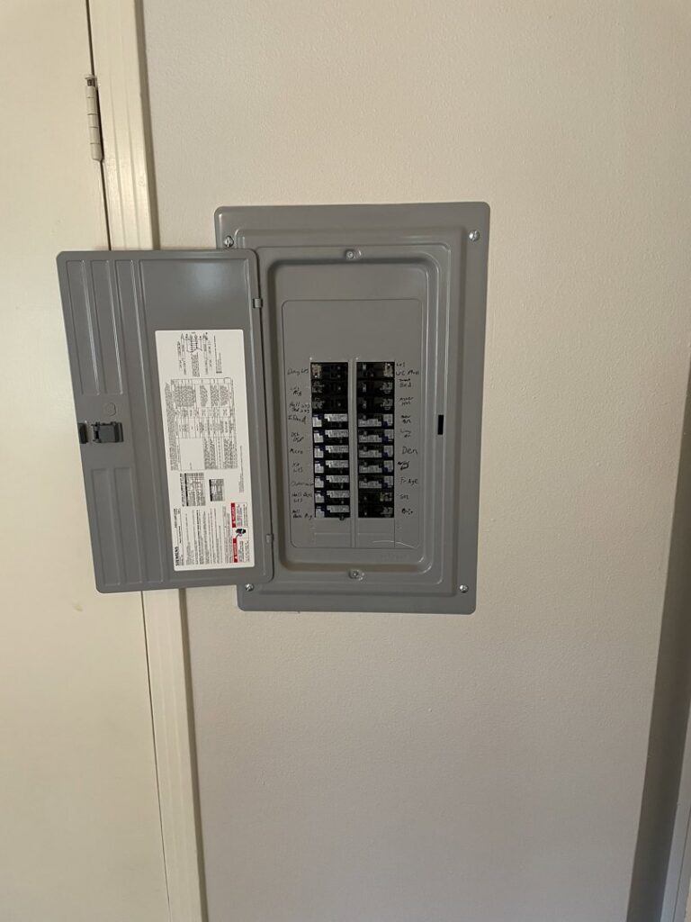 An open electrical breaker panel showing circuit breakers, serviced by Outlaw Home Services, LLC in San Antonio, Tx.