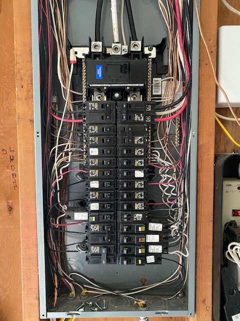 An open electrical breaker panel showing complex wiring, serviced by OutToday Electrical, Heating, Plumbing, and Air in Bellevue, WA