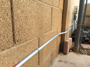 Electrical conduit installation running along a block wall by Earth Electric in Mesa, AZ
