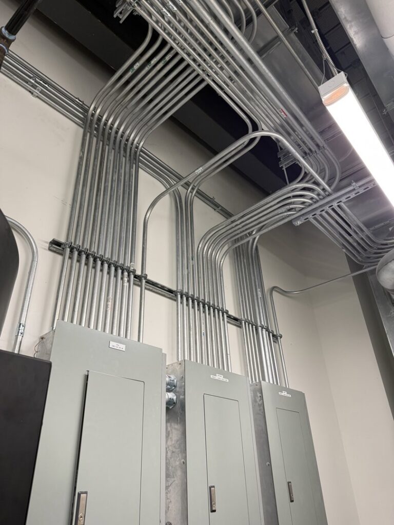 Detailed view of electrical conduit and panel installation by Cummings Electric in South Burlington, VT.