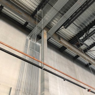 Electrical conduit and various piping installed on the ceiling of a commercial space by Tri-Area Electrical Construction in Cape Coral, FL.